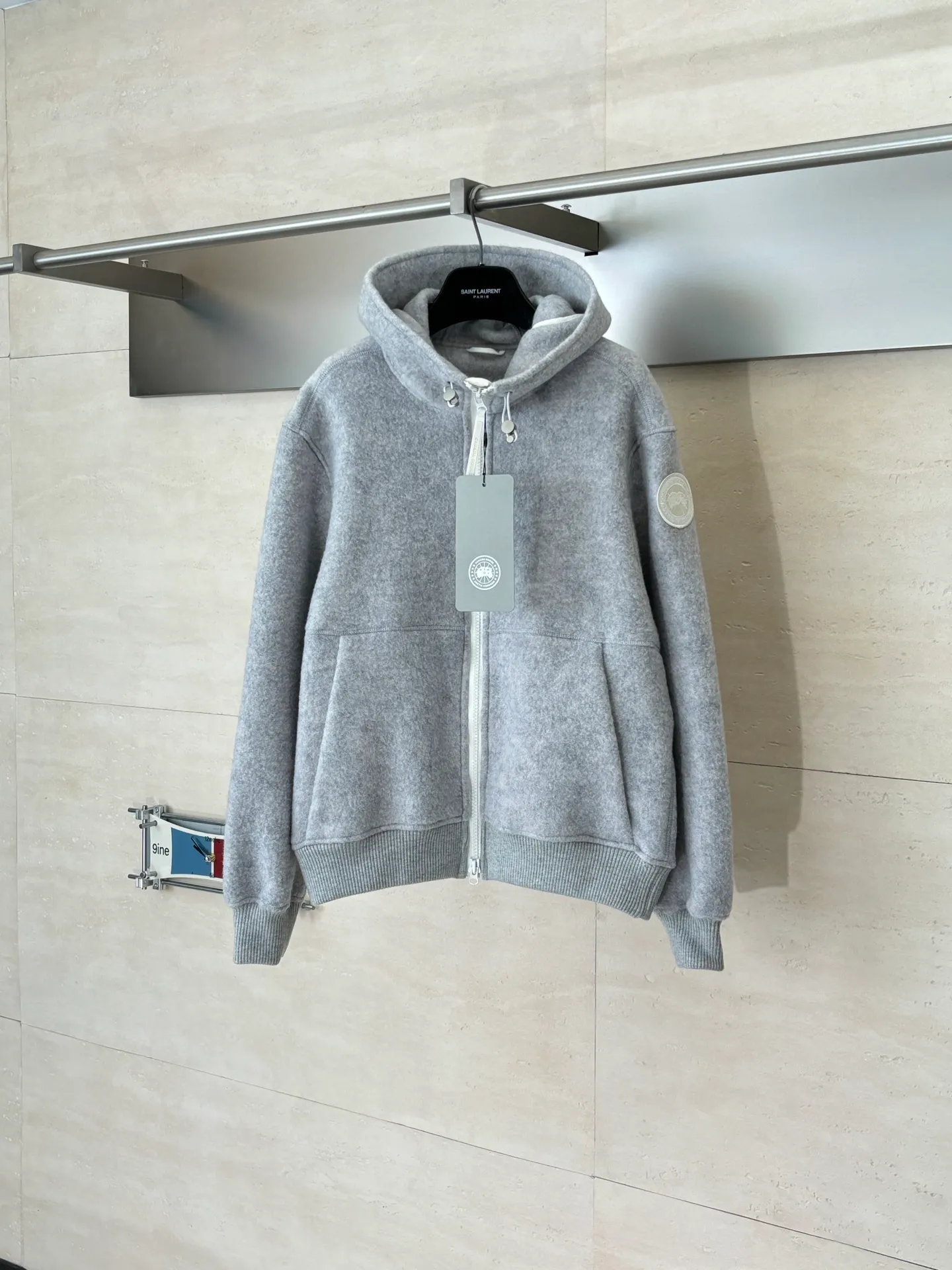 P810 Canada Goos*/Big Goose Fleece Badge Hooded Jacket The fabric is made of wool as the main body, with a very small amount of spandex and polyester fiber blended into the wool fleece fabric. The sleeves and hem are closed with 2×2 ribbing. Its strong elasticity can closely fit wrists and waists of different thicknesses, forming an effective 'seal' to prevent cold wind from blowing back. It can still maintain its original shape after repeated stretching and use, and is not easy to loose and deform. And the ribbed cuffs can convey a sense of design and enhance the visual beauty.  Size：S/M/L/XL